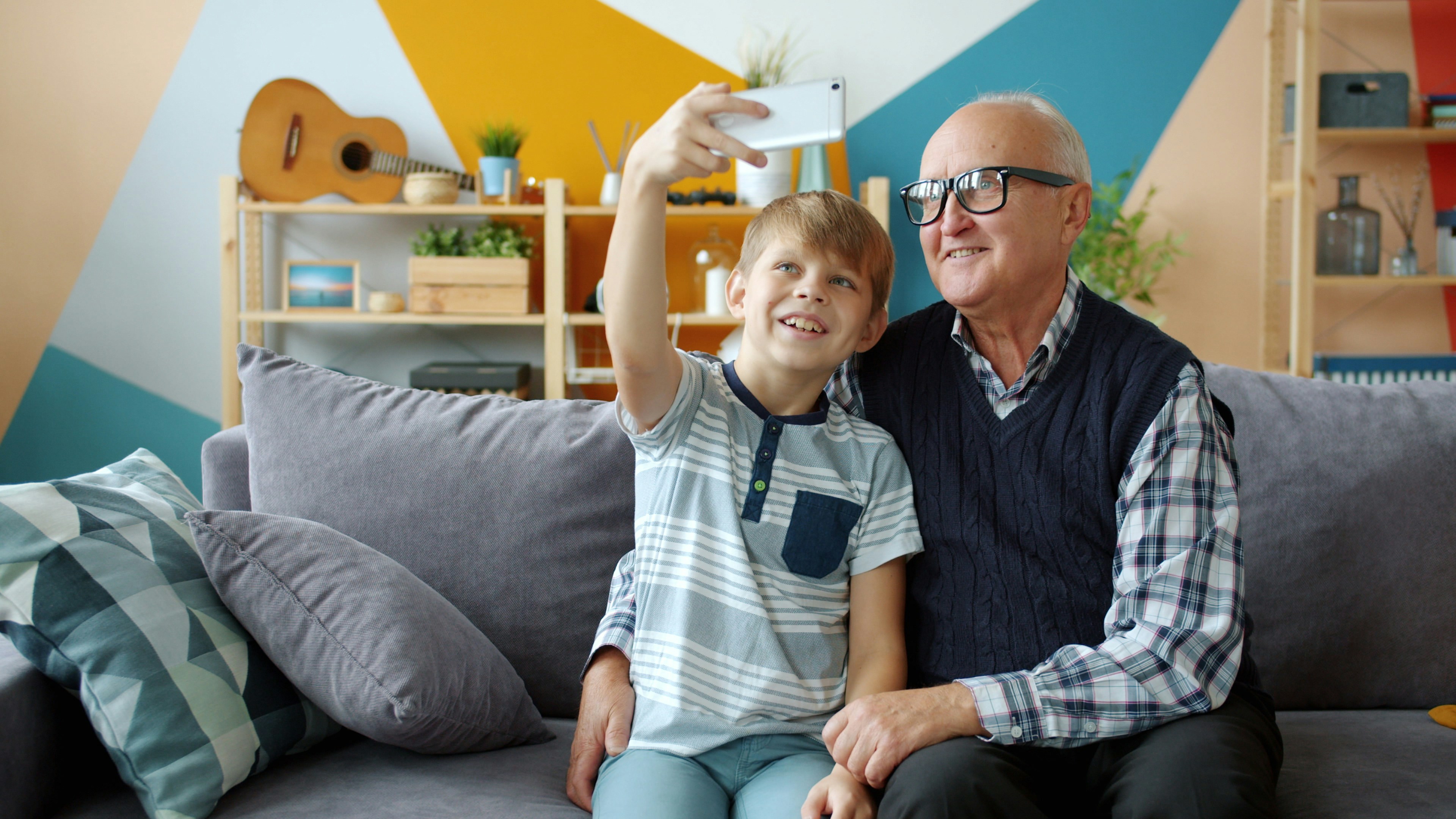 Enkel und Großvater machen gemeinsam ein Foto mit dem Smartphone